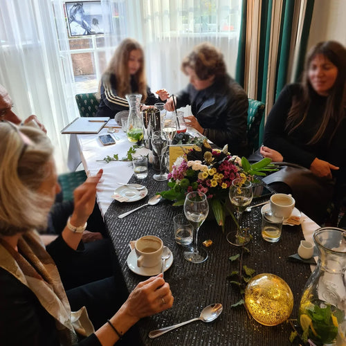 People gathered around a decorated table with flowers, drinks and coffee at a remembrance meal